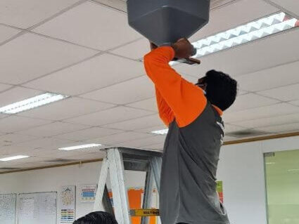 Technicians performing air balancing for ACMV system in Singapore office